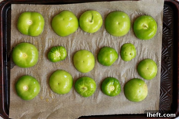 Tomatillo halves on a baking sheet before going into the oven to roast. 