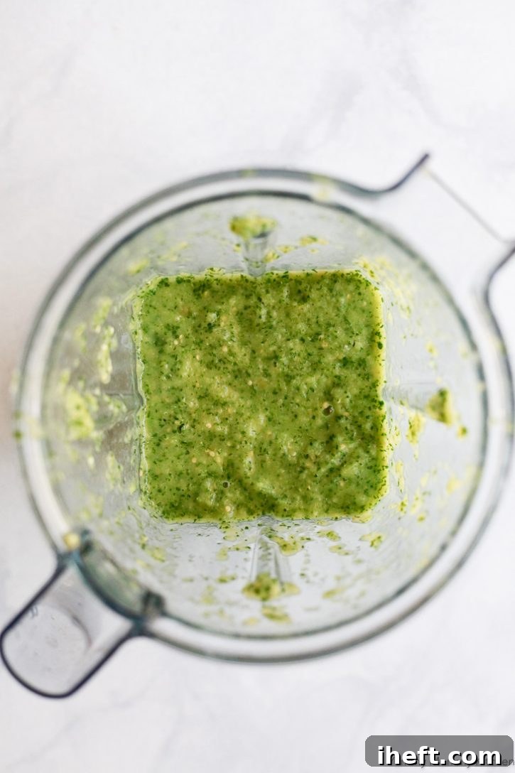 Bright green roasted tomatillo salsa verde in a made in a blender. 