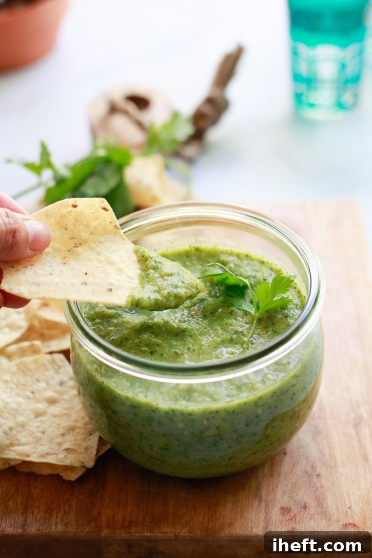 A chip dipped into homemade green roasted tomatillo salsa verde is a delicious snack. 