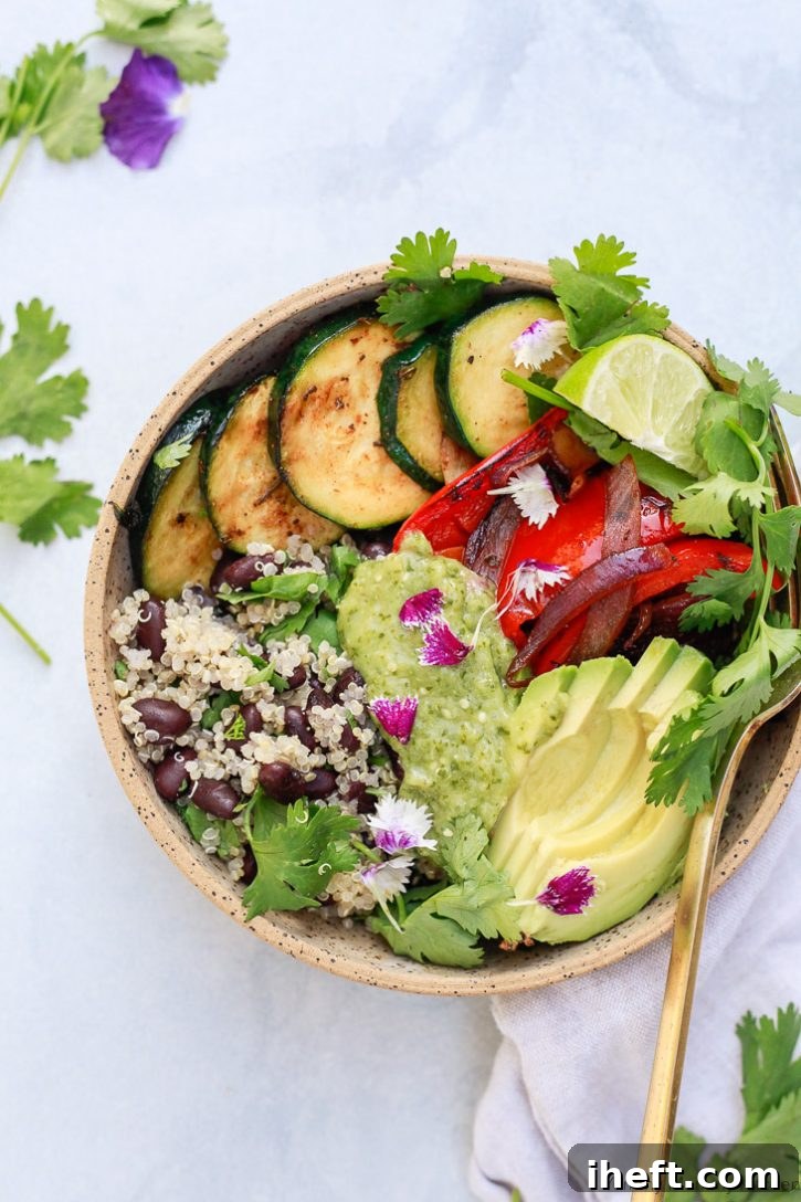 A beautiful vegan burrito bowl with quinoa, black beans, vegetables, avocado, and homemade roasted tomatillo salsa verde. 
