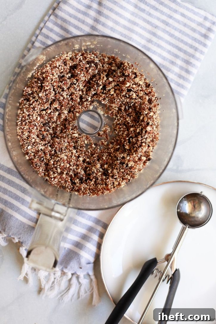 The perfectly blended ingredients for healthy no-bake oatmeal cookies, now cohesively combined in a food processor and ready to be rolled into delicious and nourishing cookie balls.