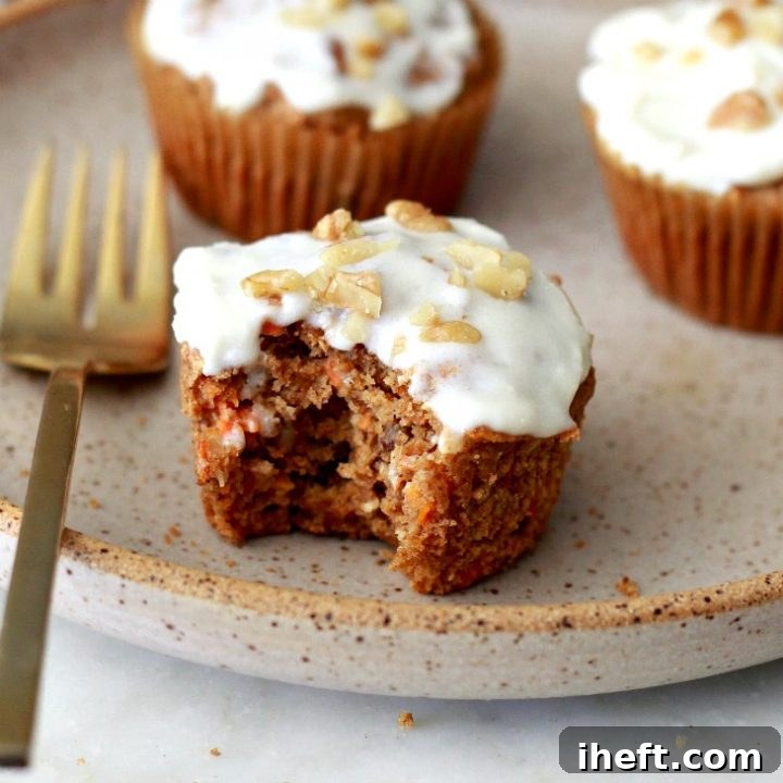 Delicious Gluten Free Carrot Muffins topped with vegan cream cheese frosting, ready to be enjoyed.