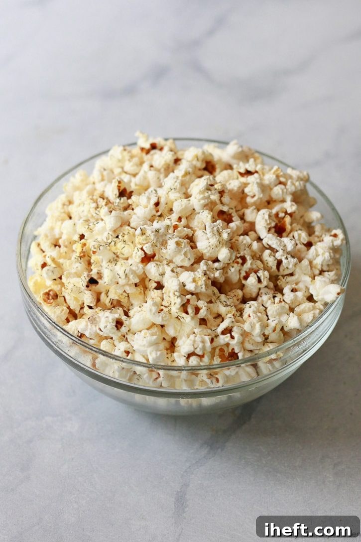 Homemade stovetop popcorn seasoned with tangy dill pickle flavor, a unique and zesty snack.