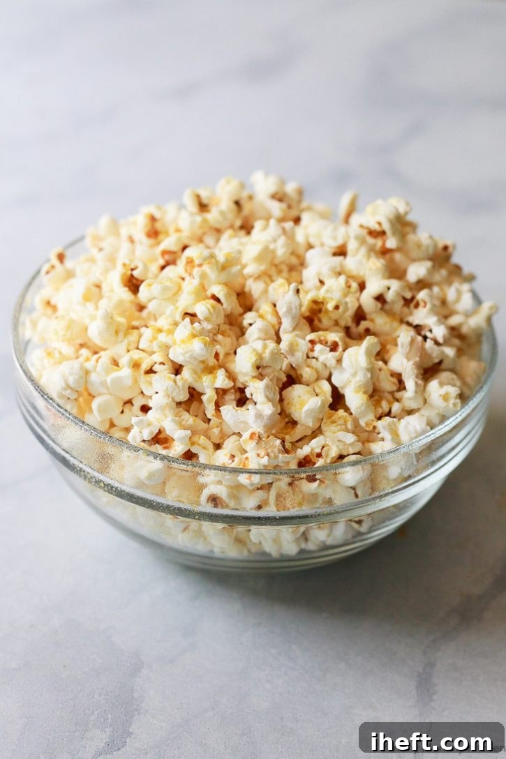 Homemade stovetop popcorn seasoned with nutritional yeast and a pinch of salt, offering a healthy and tasty vegan snack with a cheesy flavor.