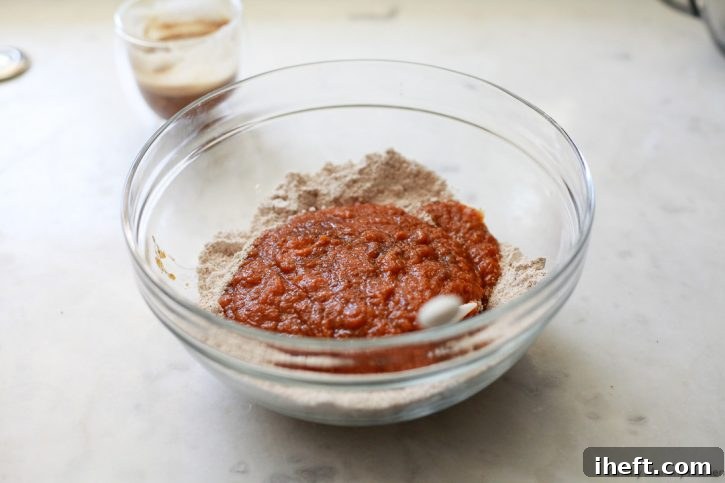 Wet pumpkin muffin ingredients are added to dry flour ingredients. 
