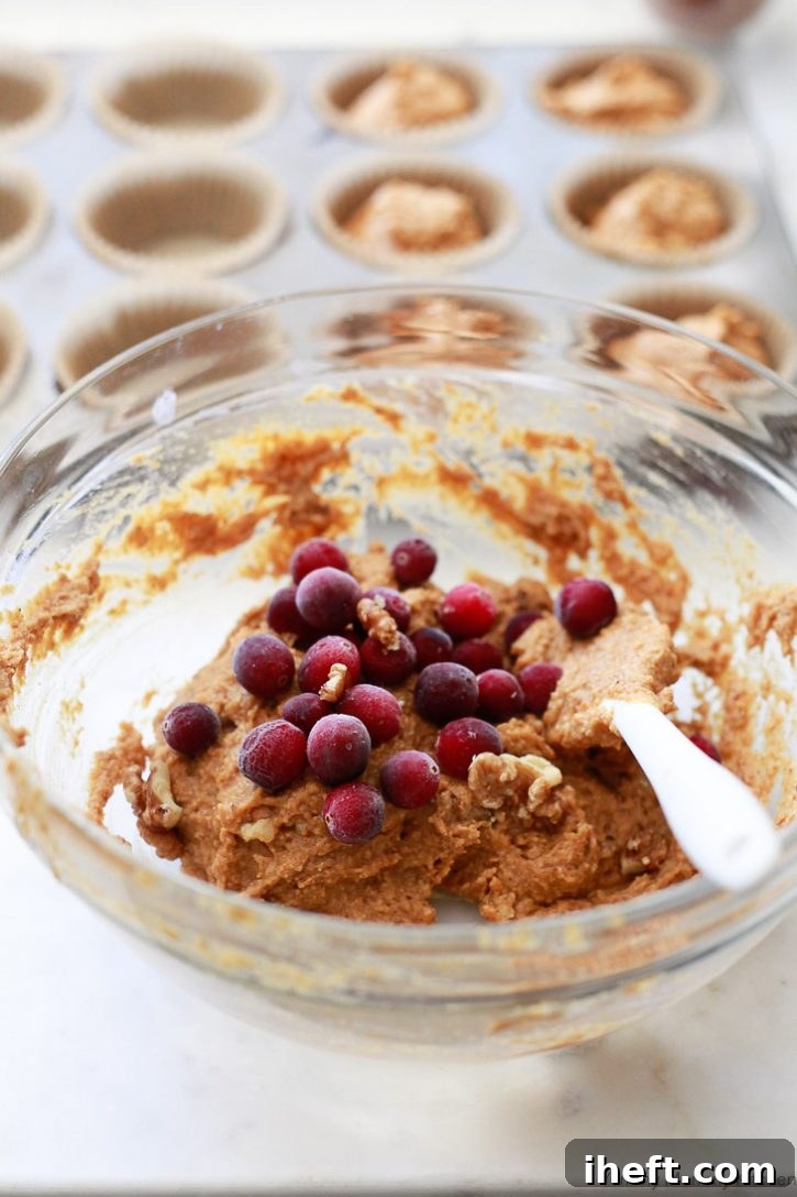 Fresh cranberries get folded into vegan pumpkin muffin batter for muffins. 
