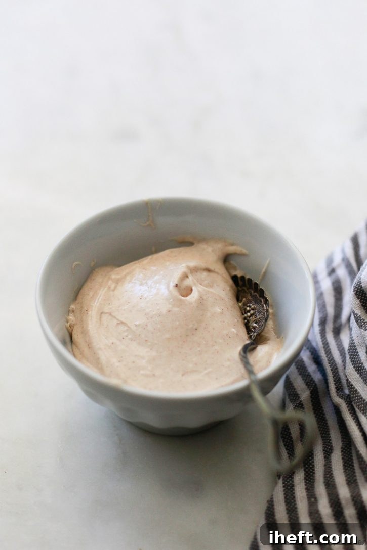 A small bowl of cinnamon dairy-free vegan cream cheese frosting for pumpkin muffins. 