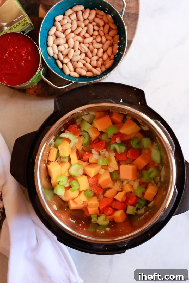 Onions, butternut squash, carrots, and celery are gently sautéed in the Instant Pot, forming the flavorful base for this easy minestrone recipe before being pressure cooked with a blend of beans, tomatoes, pasta, and rich broth.
