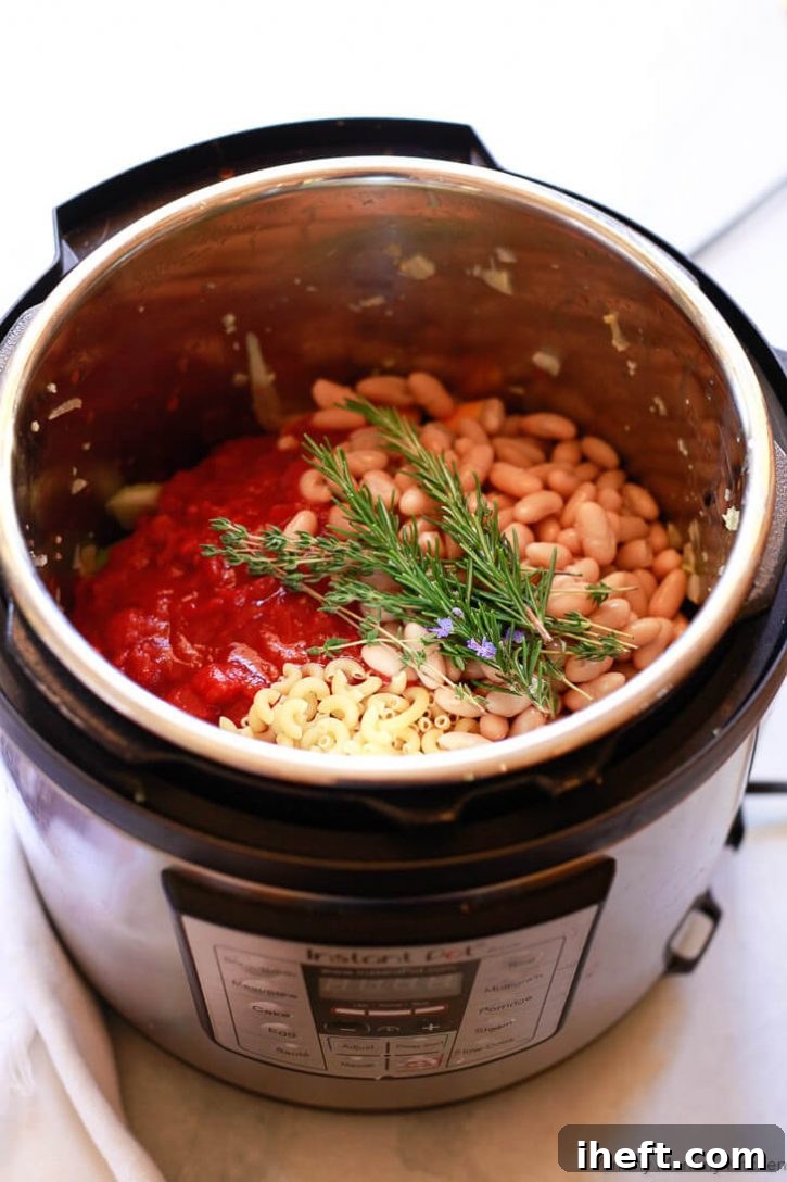 The Instant Pot filled with a colorful medley of sautéed vegetables, beans, pasta, and broth, ready for pressure cooking. This hearty and delicious easy minestrone recipe promises a wonderful vegetarian or vegan Instant Pot dinner.