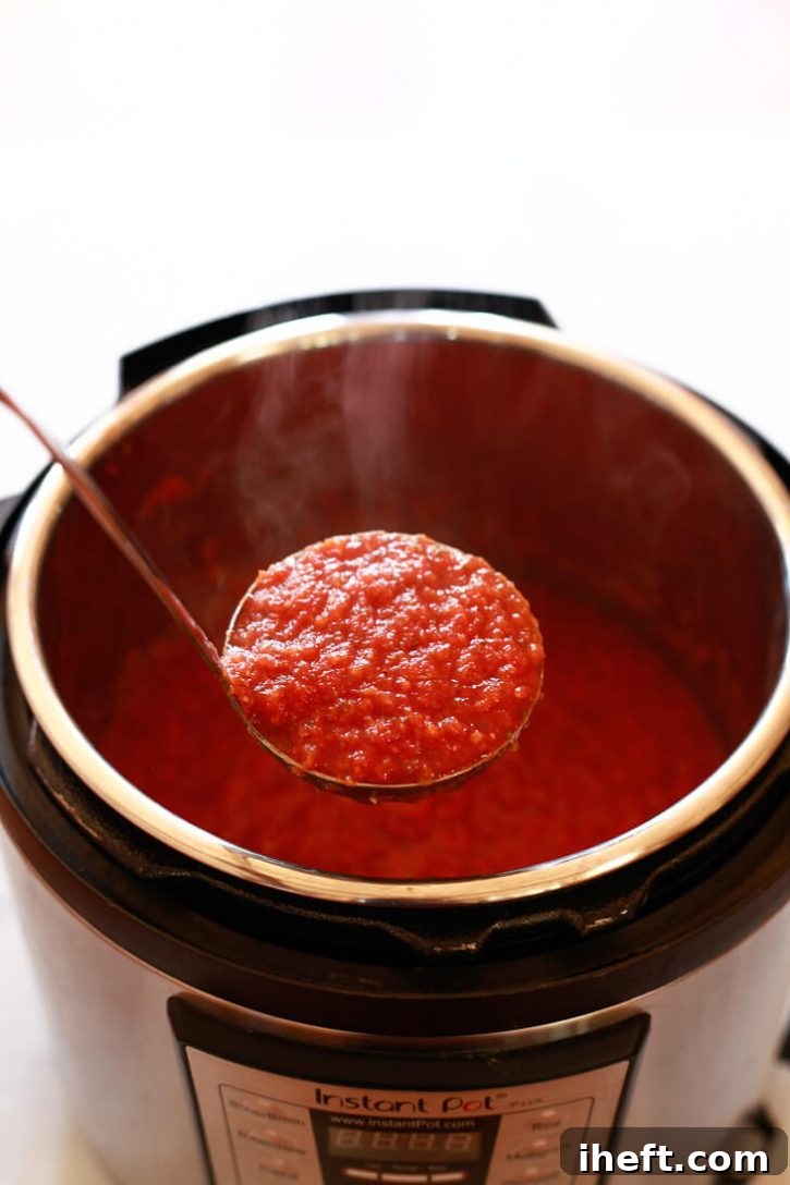 Beautiful, steaming homemade marinara spaghetti sauce, rich and thick, being ladled out of an Instant Pot, showcasing its vibrant color and texture.