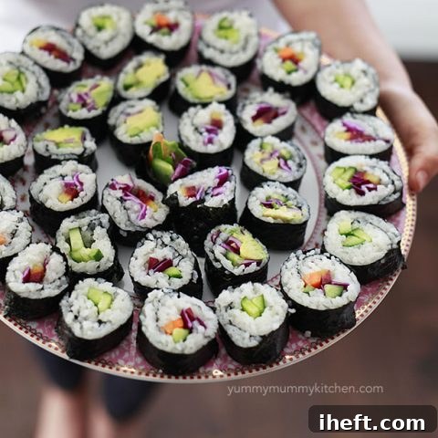 A large platter filled with beautifully arranged vegan sushi rolls, garnished and ready to be served.