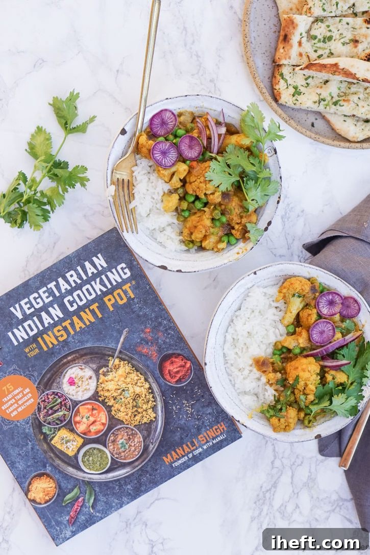 Bowls of Gobi Matar Korma (Cauliflower and Pea Coconut Curry) with rice, cilantro, and purple radish on a counter with the Vegetarian Indian Cooking with your Instant Pot cookbook, highlighting a delicious vegan Indian meal.