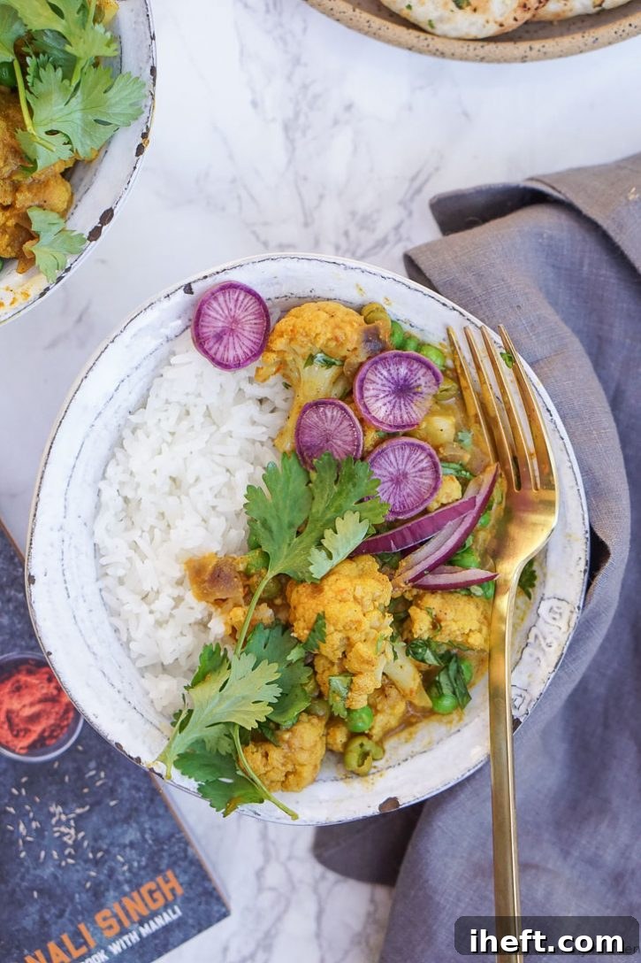 Bowl of Indian coconut curry with cauliflower and peas made in the Instant Pot pressure cooker. This delicious coconut curry is vegetarian or vegan and a perfect plant-based meal. 