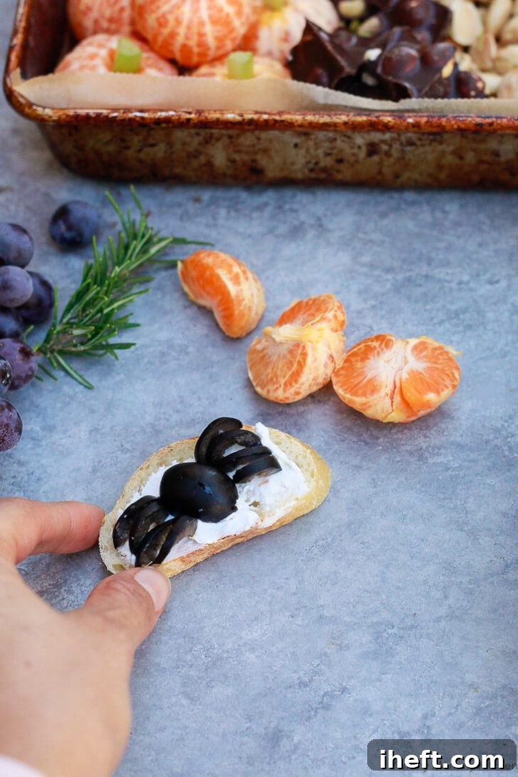 A charming and delicious Halloween spider appetizer: a black olive creatively transformed into a spider, perched atop a delicate crostini smeared with creamy cheese. A perfect, cute, and savory finger food idea for any Halloween party.