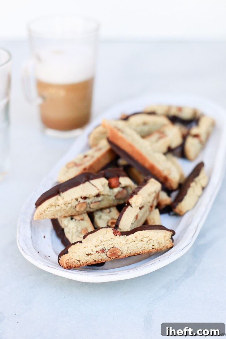 A plate of chocolate-dipped almond biscotti. These healthier biscotti or cantucci are made with almond flour and are gluten-free and vegan, showcasing a perfect golden brown hue.