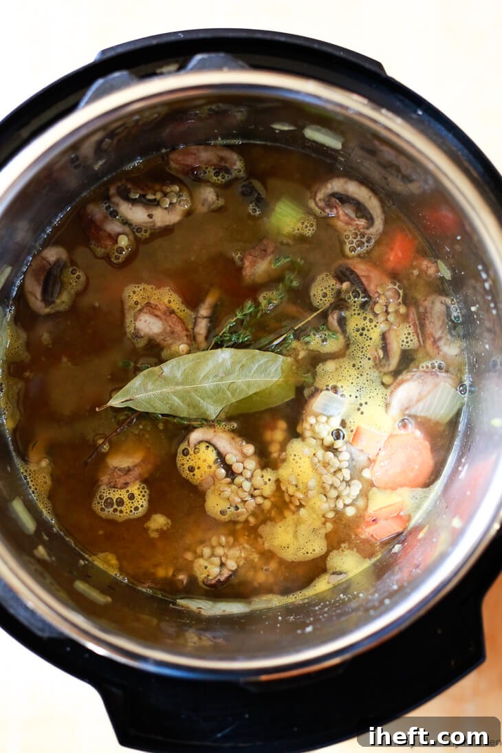 Ingredients for vegan lentil soup are in an Instant Pot pressure cooker ready to cook. 