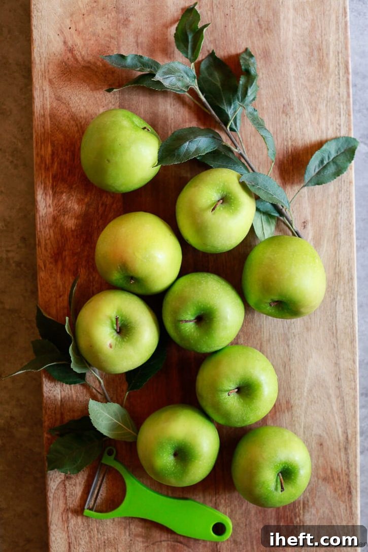 Green Granny Smith apples on a cutting board ready to get peeled for apple crumble pie. 