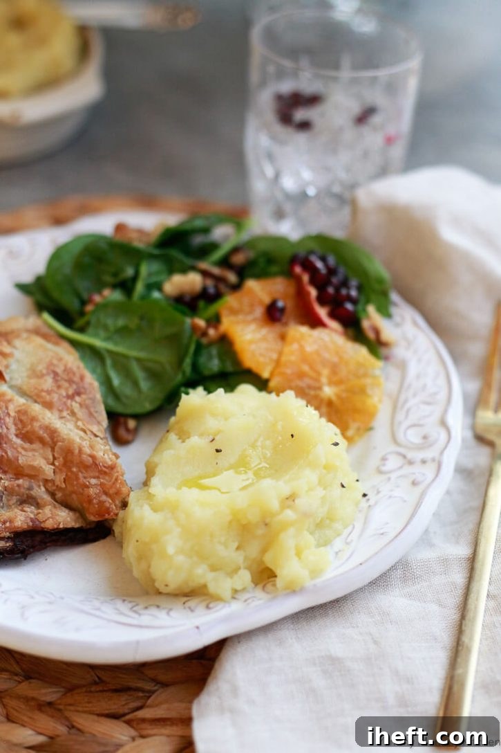A vegan Thanksgiving or Christmas dinner plate with vegan mashed potatoes, Wellington, and salad. 