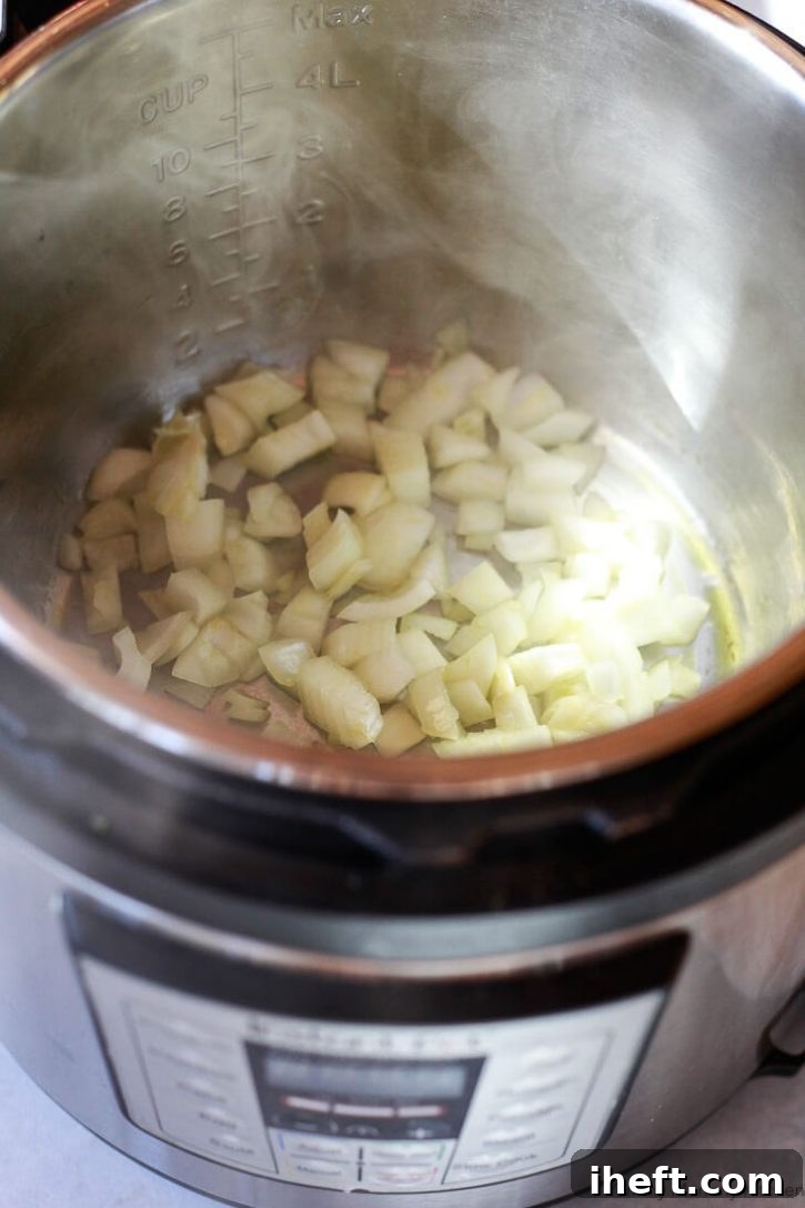 Chopped onions saute in an Instant Pot pressure cooker with a little avocado oil to start a simple vegetable risotto recipe. 