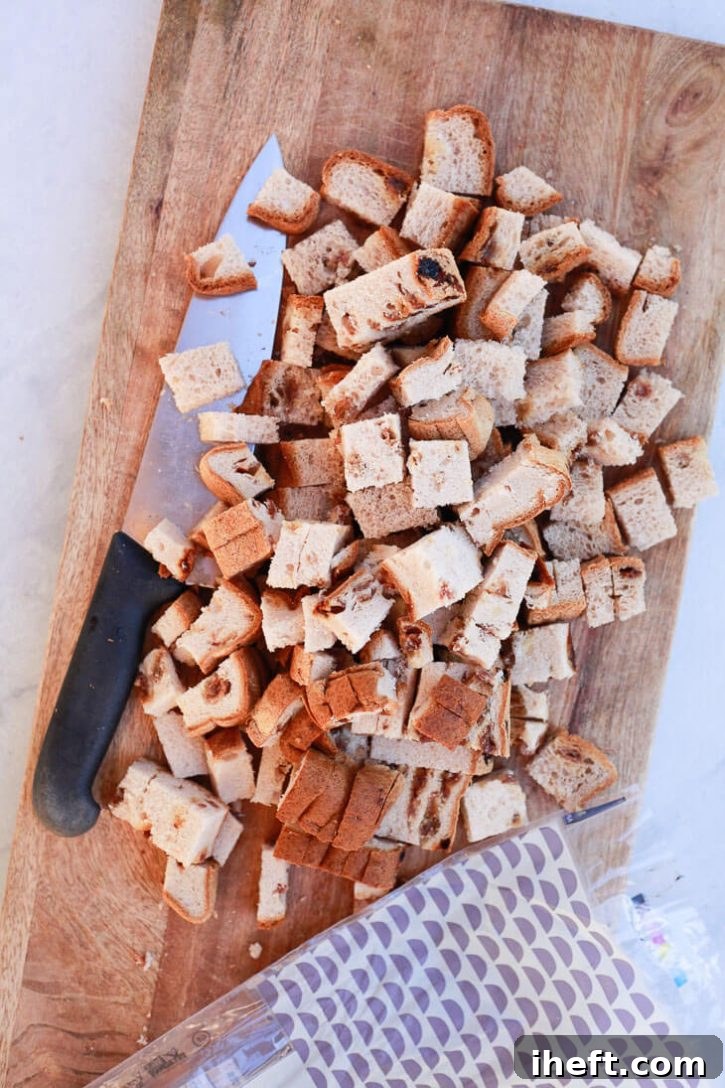Cubed gluten-free cinnamon raisin bread in a baking dish.