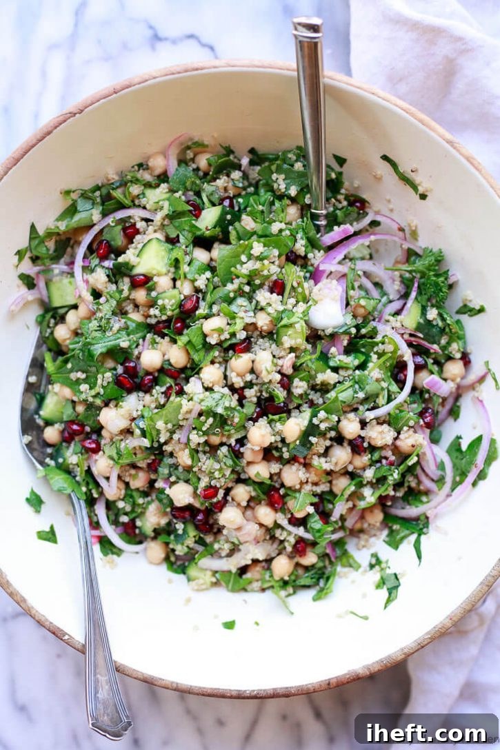 A beautifully presented vegan chickpea quinoa salad in a pristine white salad bowl, ready to be enjoyed.