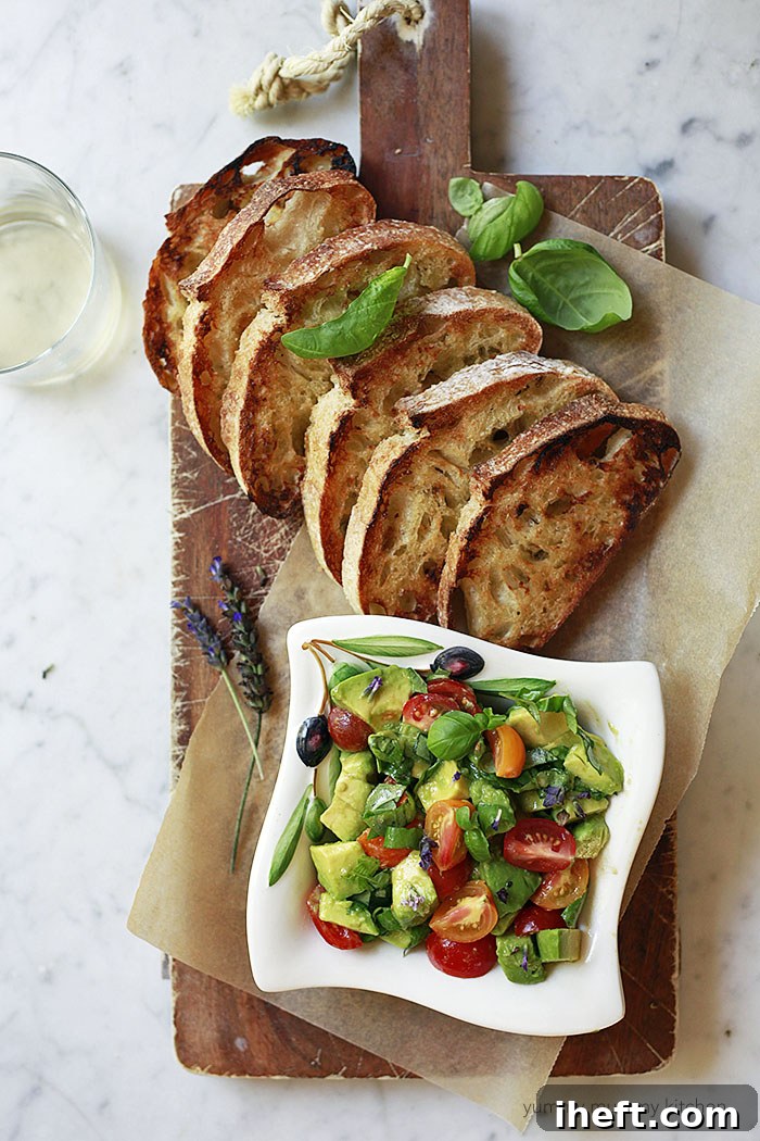 A bowl of avocado bruschetta served with toasted bread is a delicious appetizer. 