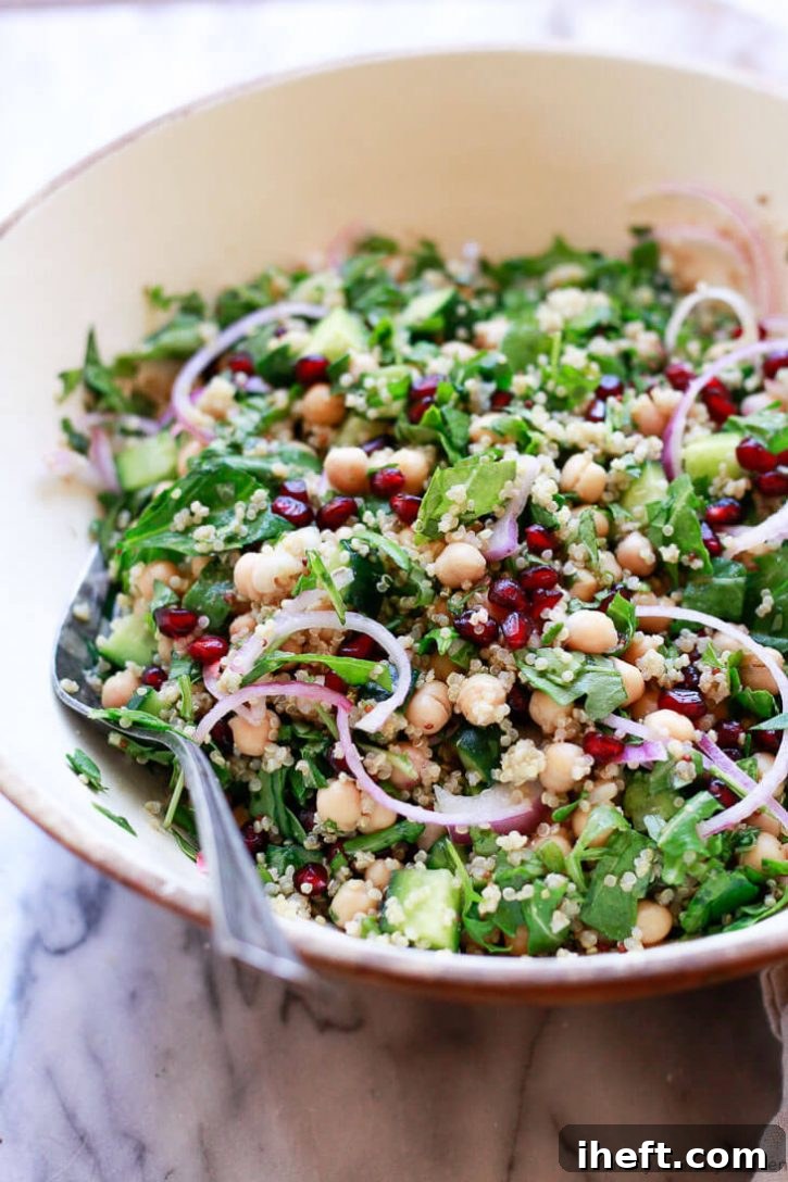 Chickpea quinoa salad with spinach, red onions, and pomegranate. A delicious vegan winter salad. 