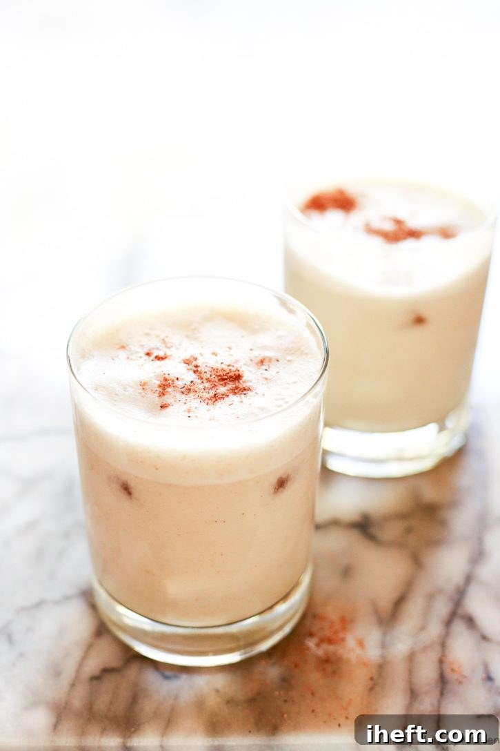 Glasses of cold homemade healthy vegan eggnog topped with nutmeg. 
