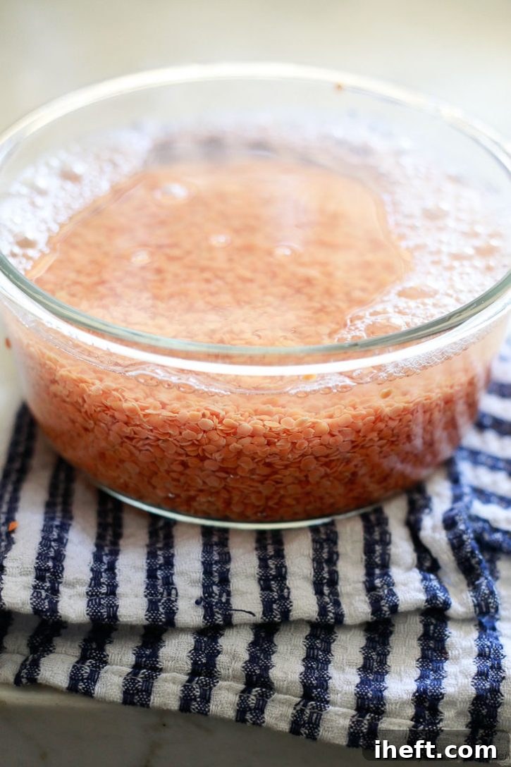 A bowl of red lentils soaking in water. Lentils don't need to be soaked, but should be rinsed and sorted before cooking. 
