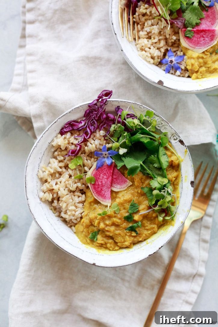 Two bowls of red lentil dal with rice and herbs. 