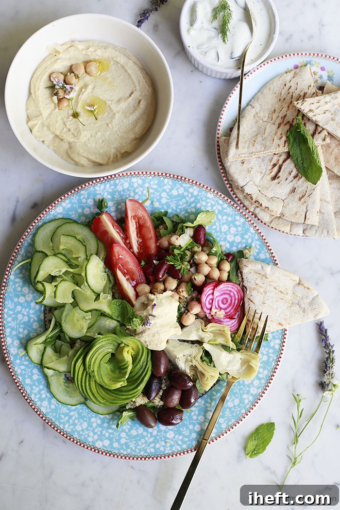 A beautiful Greek inspired meal prep bowl with hummus and pita bread. 