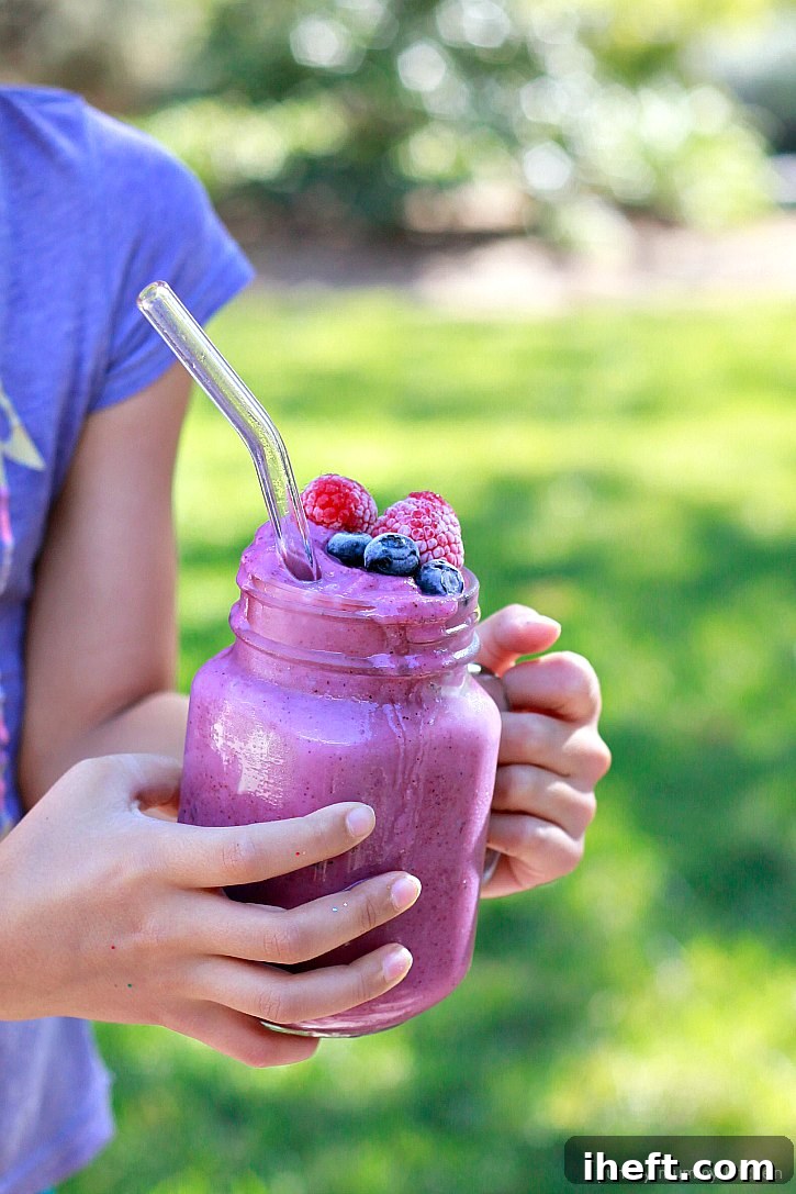 A refreshing blueberry cauliflower smoothie served in a tall glass, garnished with fresh blueberries and a colorful straw. This easy recipe is a fantastic way to get kids to eat more vegetables without a fuss.