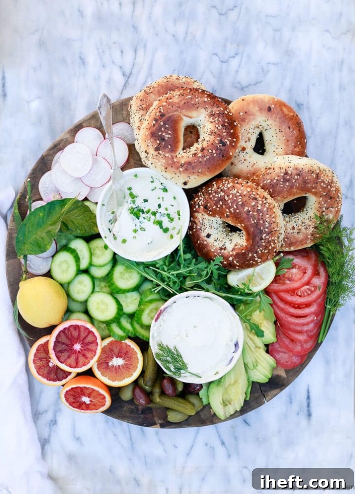 A colorful healthy breakfast or brunch platter with bagels, vegan cream cheese, fruits and vegetables. 
