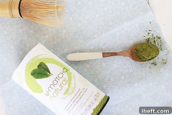 Matcha powder in a spoon with a matcha whisk for making a matcha latte. 