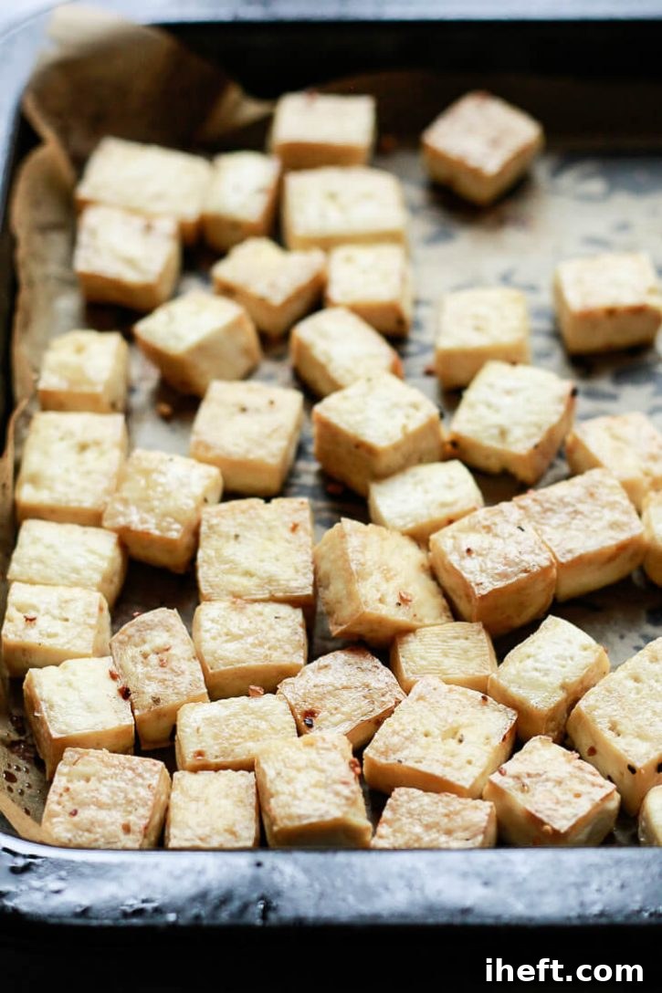 Golden brown, perfectly crispy baked tofu cubes, glistening and just out of the oven, ready to be glazed or served.