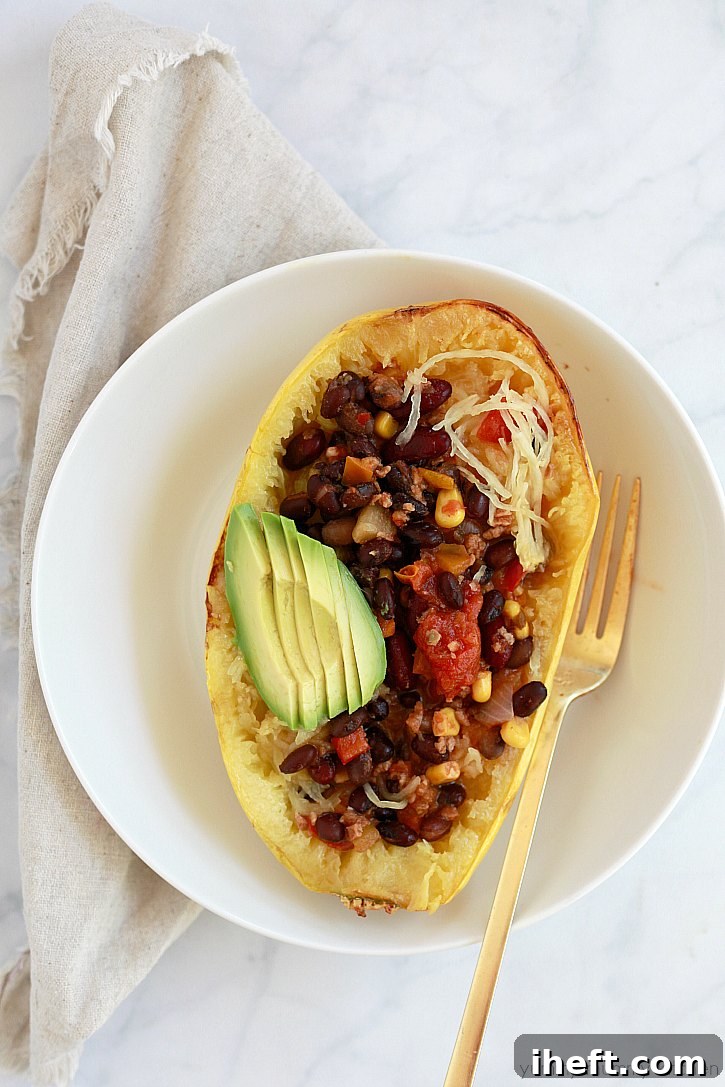 Delicious roasted spaghetti squash boats, filled with hearty chili and topped with creamy avocado, offering a delightful vegan meal option.