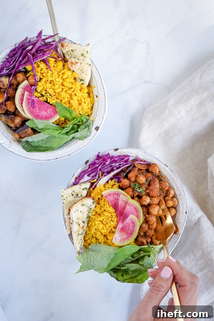 Indian Buddha Bowls made with golden turmeric rice, chana masala curry, naan, purple cabbage, watermelon radish, and fresh herbs. 