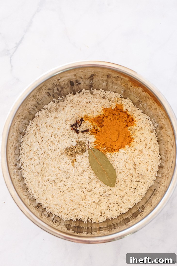 Basmati rice, cloves, turmeric, bay leaf, and fennel seeds in an Instant Pot. 