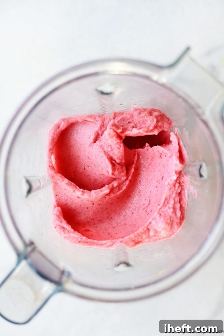 A thick strawberry banana smoothie inside a Vitamix blender. 