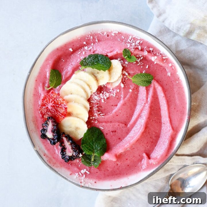 strawberry banana smoothie in a bowl topped with sliced banana