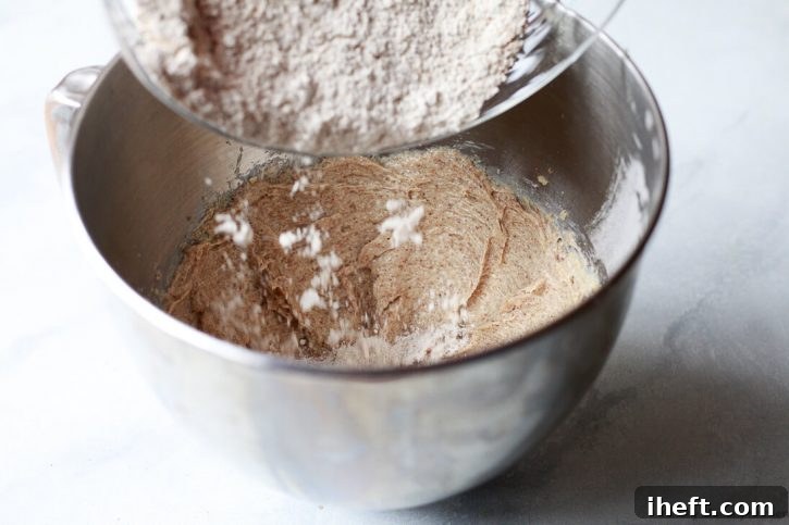 Oat flour gets poured into the creamed wet ingredients for vegan gluten free oatmeal cookies. 
