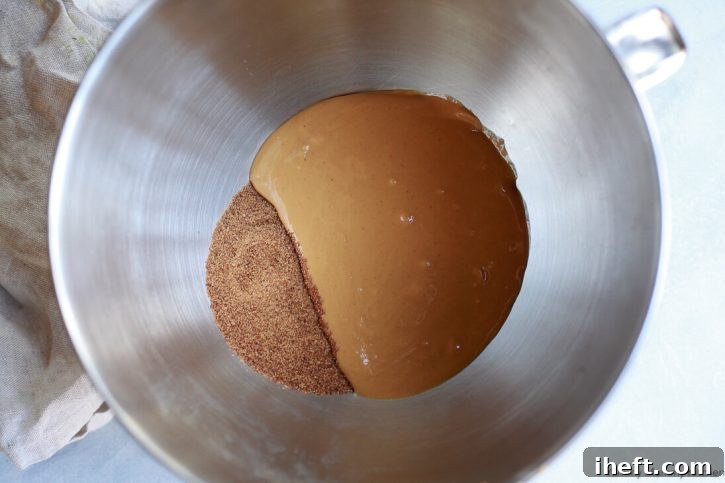 An empty mixing bowl and a few ingredients laid out on a kitchen counter, ready for the start of baking the peanut butter snack bars.