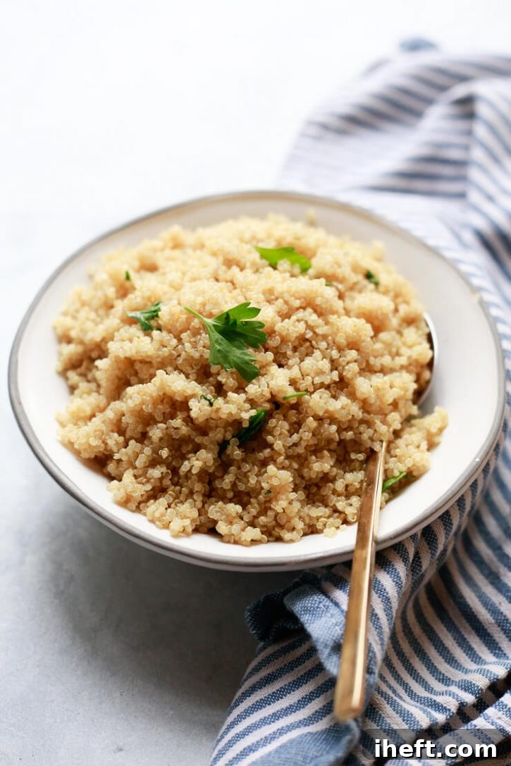 A white bowl filled with cooked fluffy white quinoa topped with parsley. 