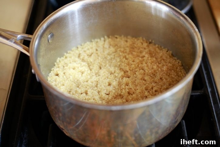 Quinoa has just finished cooking in a saucepan on the stove. 