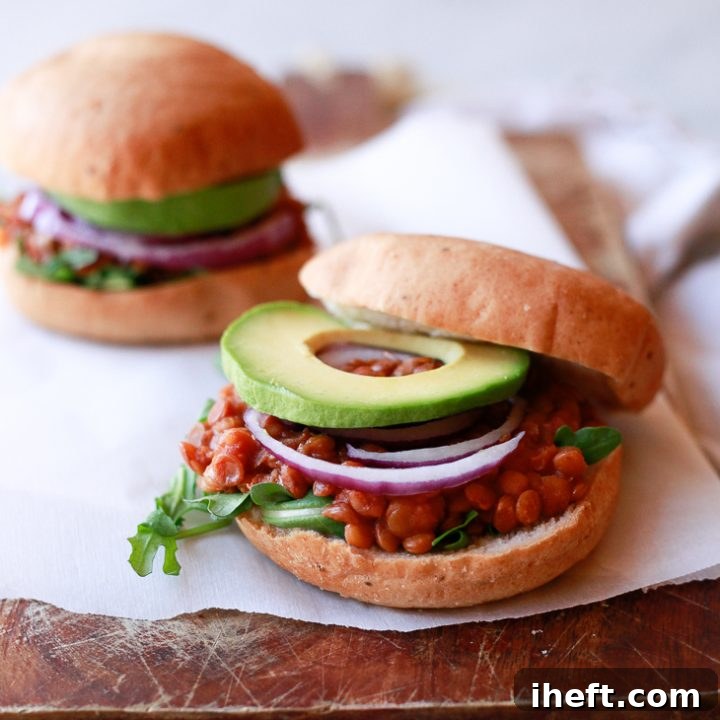 Vegan lentil sloppy joes on hamburger buns with onions and avocado.