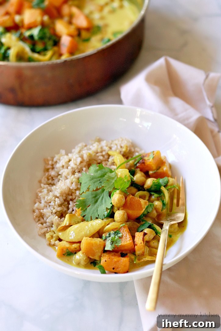 Easy coconut chickpea yellow curry with butternut squash and spinach served in a bowl.