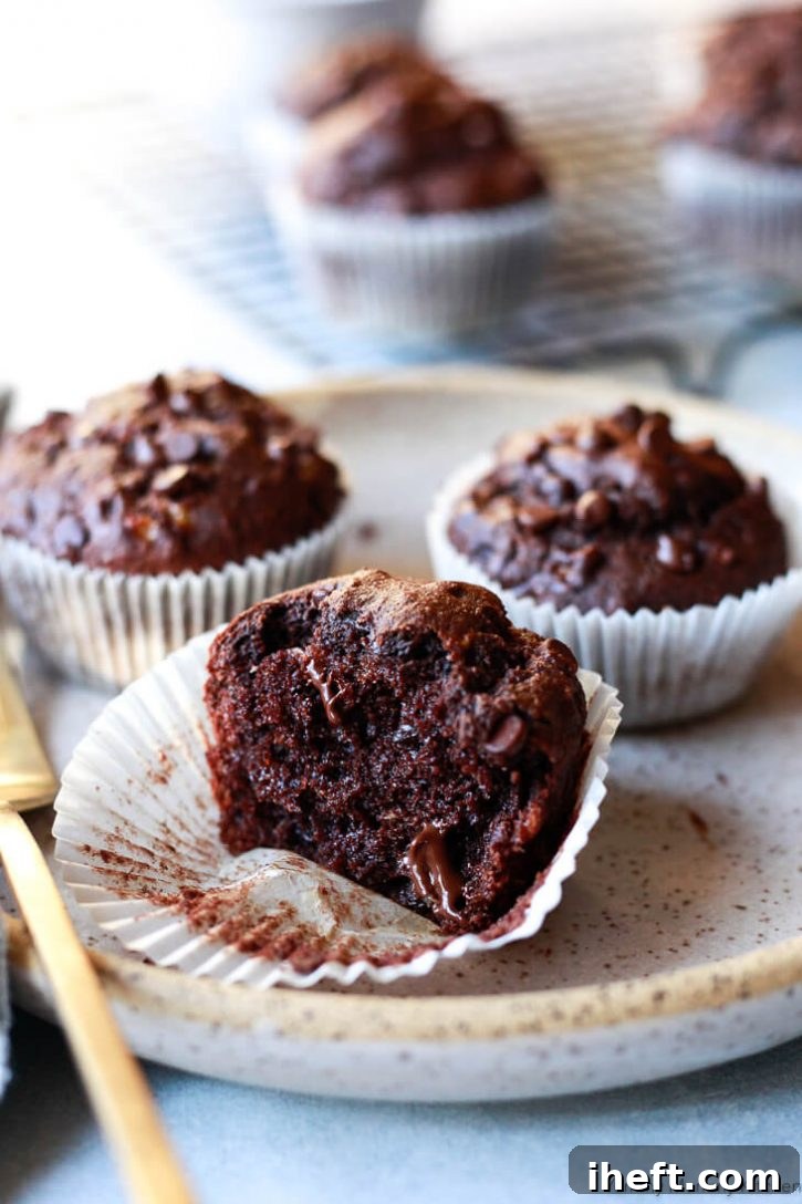 Close-up photo of half a chocolate banana muffin with melty chocolate chips.