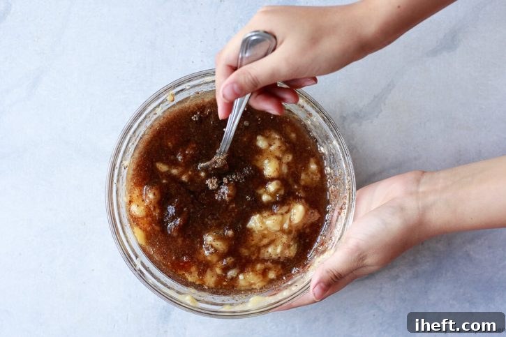 The wet ingredients for chocolate banana muffins get mixed together in a small glass bowl.