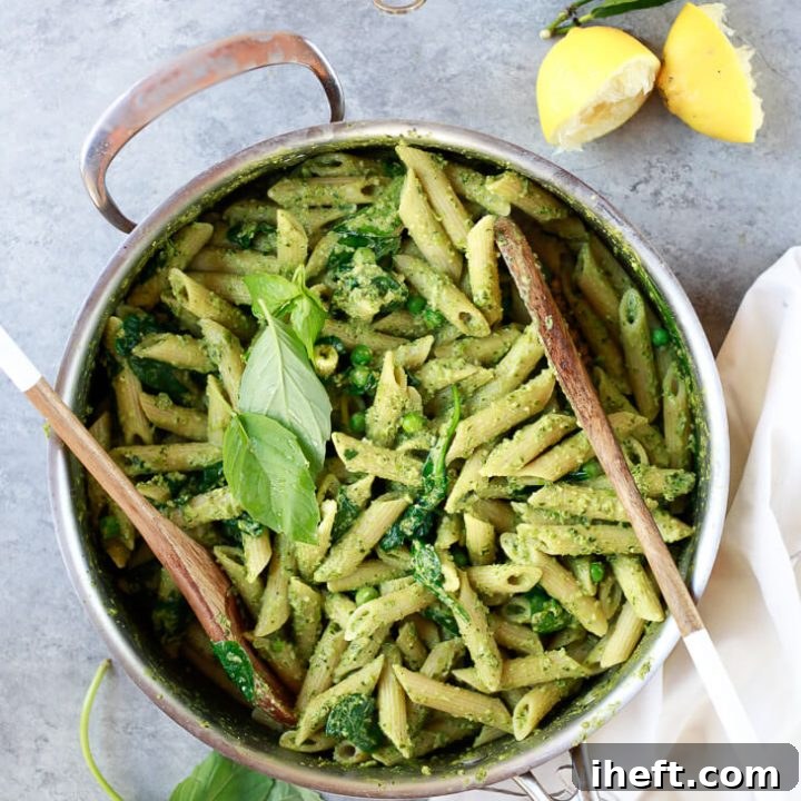 A pot filled with bright green pea and basil vegan pesto pasta.