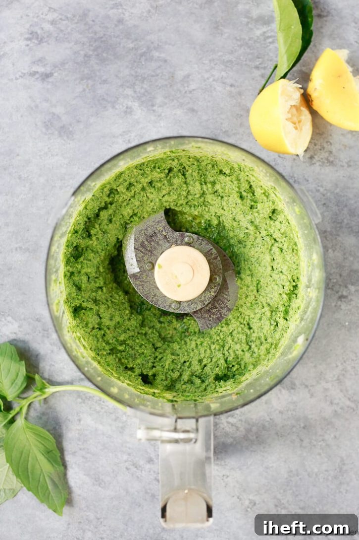 Beautiful bright green vegan pea pesto in a food processor. 